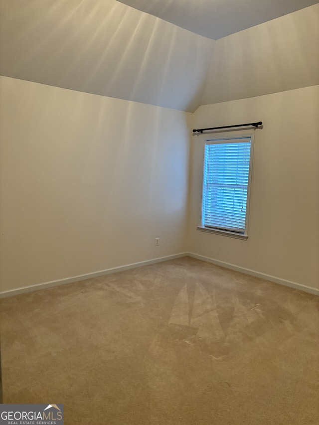 bonus room with light colored carpet and vaulted ceiling