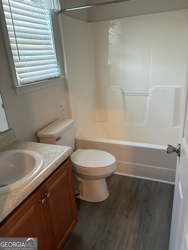 full bathroom with shower / tub combination, hardwood / wood-style floors, vanity, and toilet