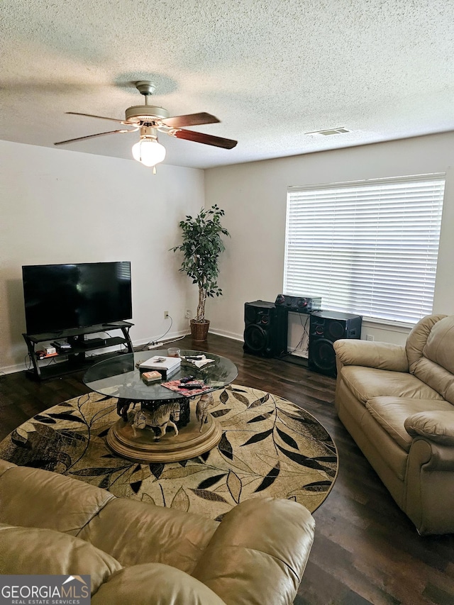 living room featuring a textured ceiling and dark wood-type flooring