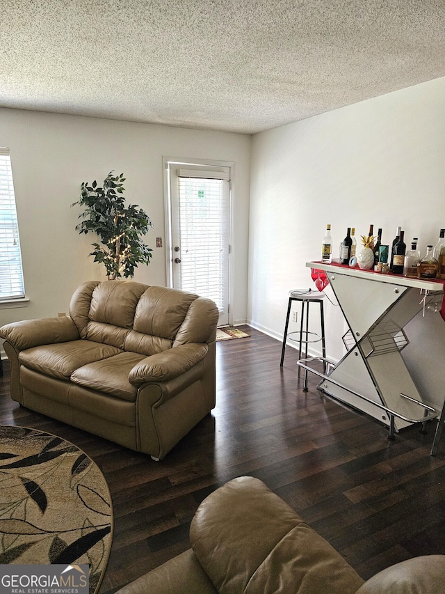 living room featuring a textured ceiling and dark hardwood / wood-style flooring