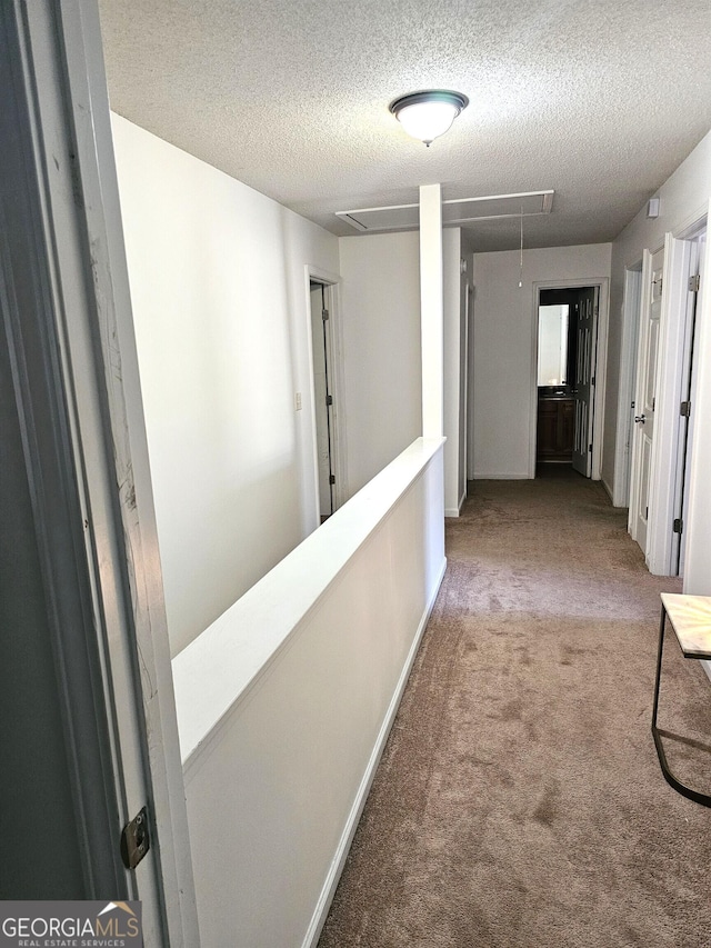 corridor featuring carpet and a textured ceiling