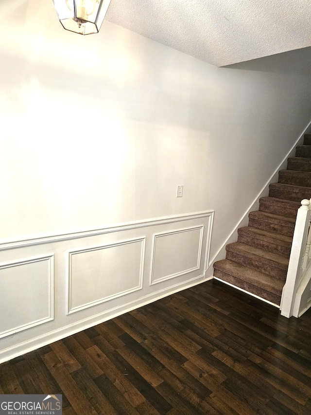 stairs featuring hardwood / wood-style floors and a textured ceiling