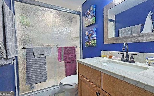 bathroom featuring an enclosed shower, vanity, and toilet