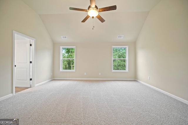 unfurnished room with ceiling fan, a healthy amount of sunlight, light carpet, and vaulted ceiling