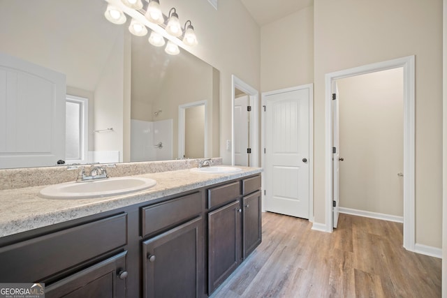 bathroom featuring vanity, a shower, high vaulted ceiling, and wood-type flooring