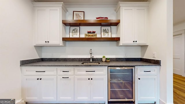 bar with wood-type flooring, white cabinetry, sink, and wine cooler