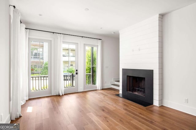 doorway to outside featuring a fireplace and light hardwood / wood-style floors