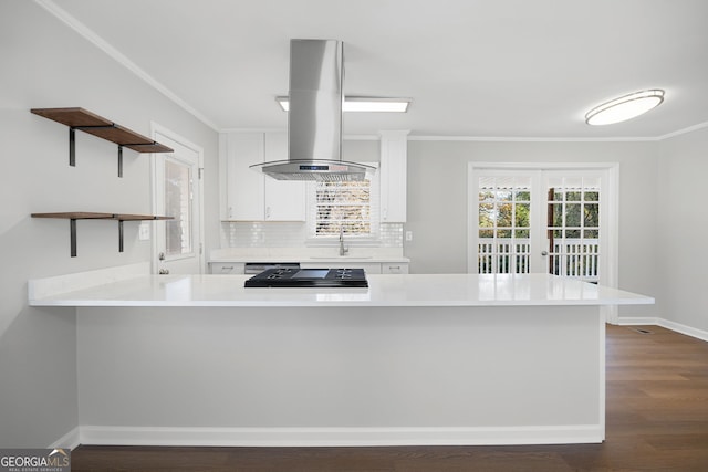 kitchen featuring white cabinets, kitchen peninsula, sink, and extractor fan