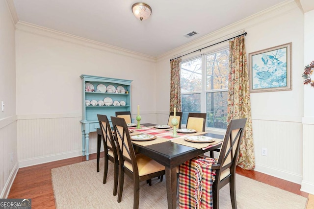 dining room featuring ornamental molding and hardwood / wood-style flooring