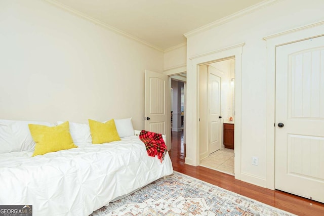 bedroom with light wood-type flooring and crown molding