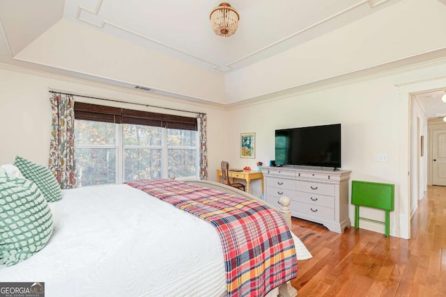 bedroom featuring a tray ceiling and light hardwood / wood-style flooring