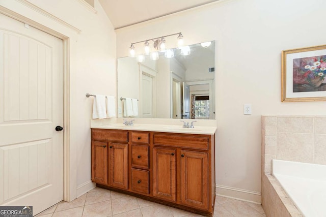 bathroom with tile patterned floors, tiled tub, and vanity