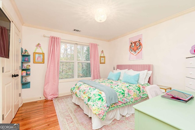 bedroom featuring crown molding and light hardwood / wood-style flooring