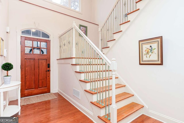 entrance foyer with a high ceiling and wood-type flooring