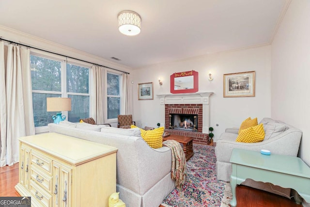 living room featuring a brick fireplace, crown molding, and wood-type flooring