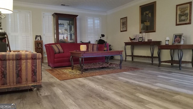 living area featuring ornamental molding and light wood-type flooring