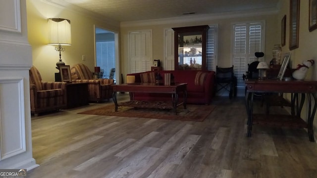 sitting room with crown molding and hardwood / wood-style floors