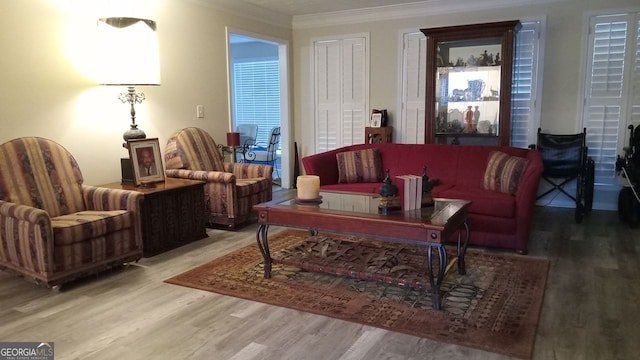 living area with crown molding and hardwood / wood-style flooring