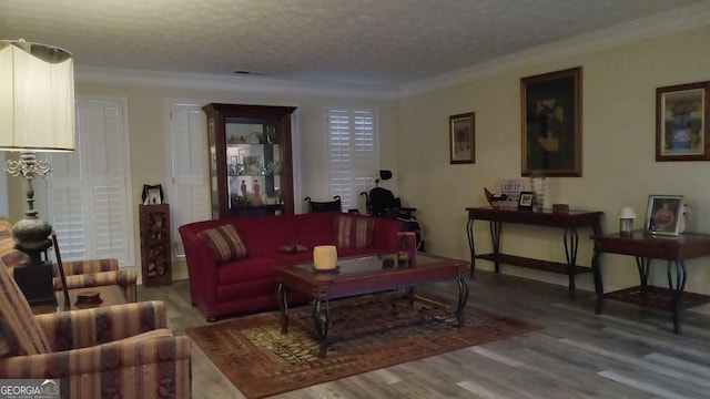 living room featuring hardwood / wood-style flooring, crown molding, and a textured ceiling