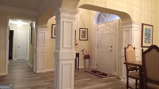 foyer with decorative columns, crown molding, and hardwood / wood-style flooring