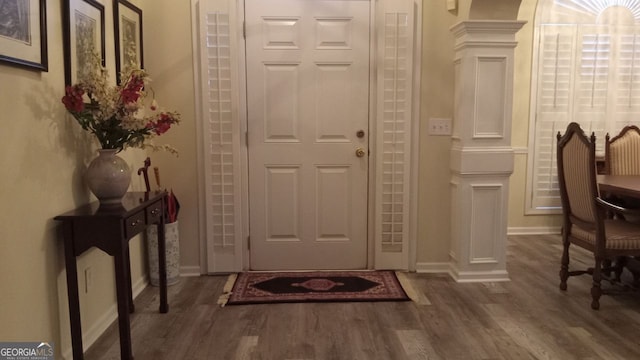 foyer entrance featuring dark hardwood / wood-style flooring and ornate columns