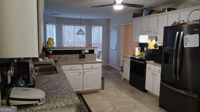 kitchen featuring sink, white cabinets, hanging light fixtures, light tile patterned floors, and black appliances