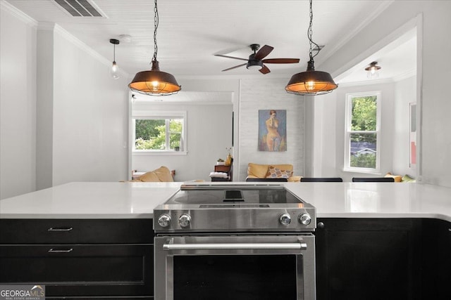 kitchen featuring stainless steel electric stove, hanging light fixtures, and a healthy amount of sunlight