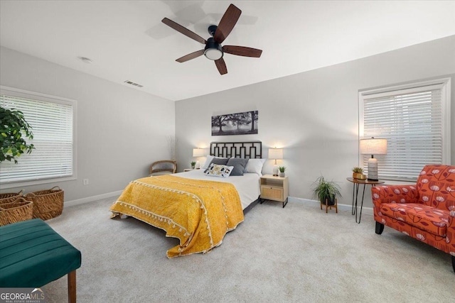 carpeted bedroom featuring multiple windows and ceiling fan