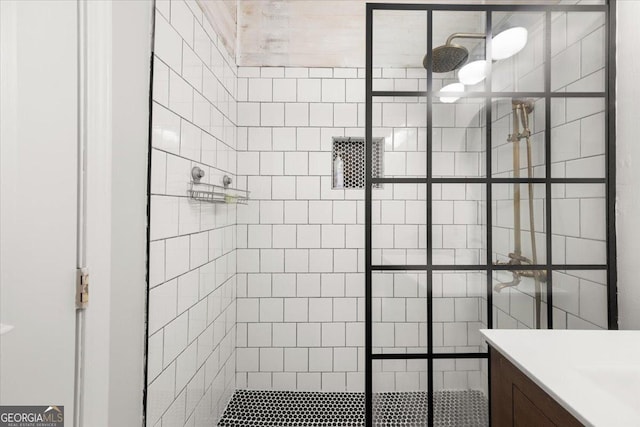 bathroom with vanity and tiled shower