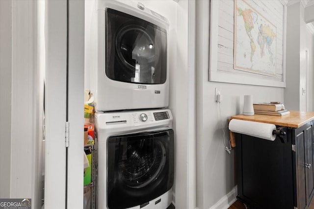 washroom with ornamental molding and stacked washer and clothes dryer