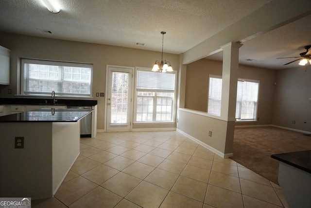 kitchen with open floor plan, light tile patterned floors, dark countertops, and white cabinetry