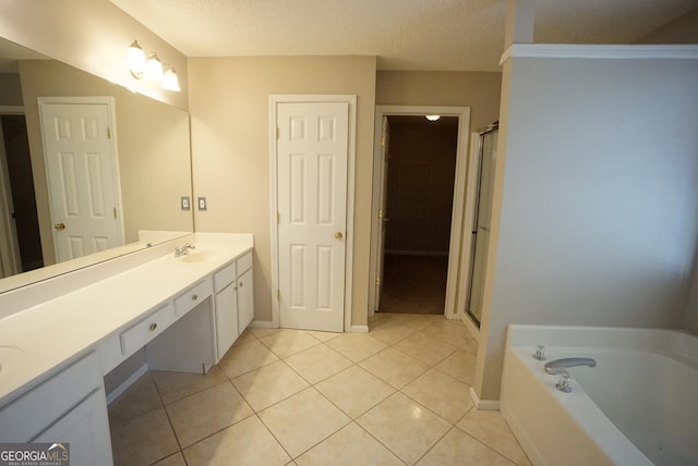 full bath with a stall shower, tile patterned floors, a garden tub, a textured ceiling, and vanity