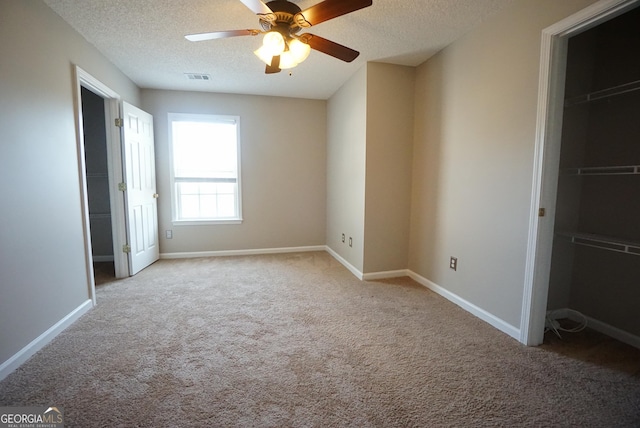 unfurnished bedroom featuring baseboards, a textured ceiling, visible vents, and carpet flooring