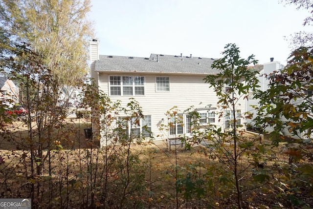 back of house featuring a chimney