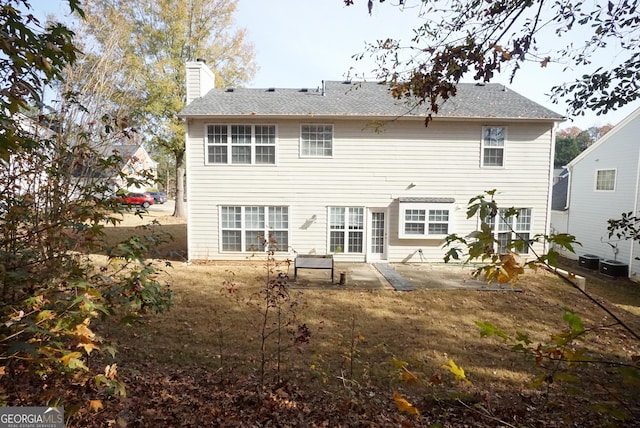 rear view of house with a chimney and a patio area