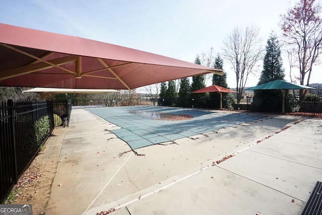 pool with a patio area and fence