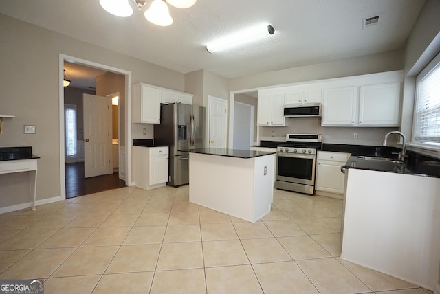 kitchen featuring light tile patterned floors, appliances with stainless steel finishes, a sink, and visible vents