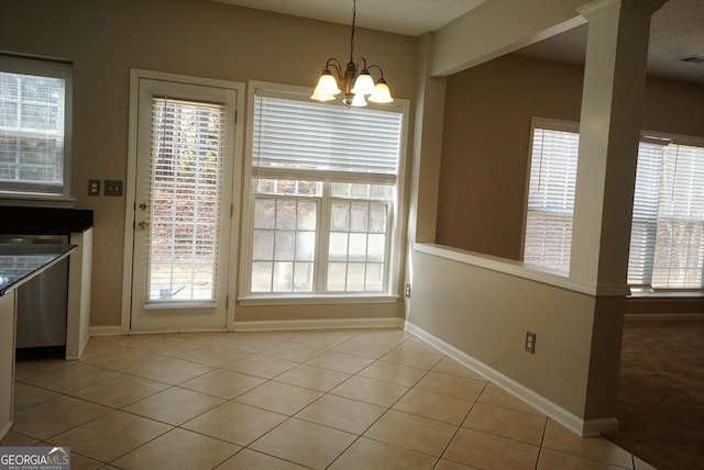 unfurnished dining area with light tile patterned floors, plenty of natural light, and a notable chandelier