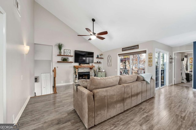 living room featuring hardwood / wood-style flooring, ceiling fan, a fireplace, and high vaulted ceiling