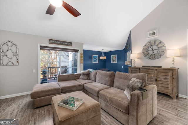 living room featuring ceiling fan, high vaulted ceiling, and light hardwood / wood-style flooring