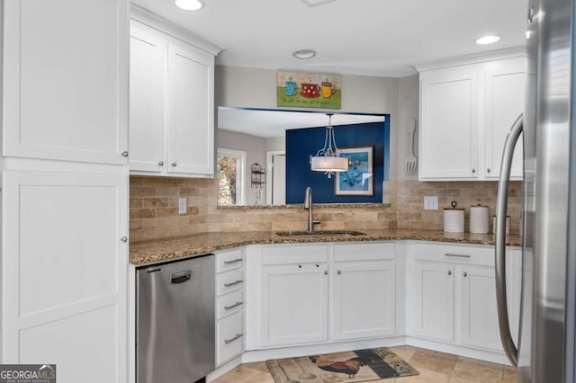 kitchen with dark stone counters, sink, tasteful backsplash, white cabinetry, and stainless steel appliances