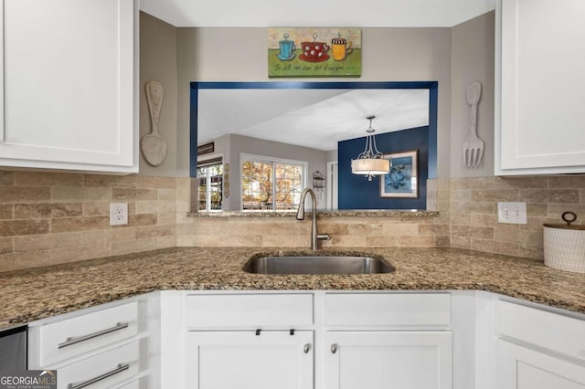 kitchen with white cabinets, pendant lighting, dark stone countertops, and sink