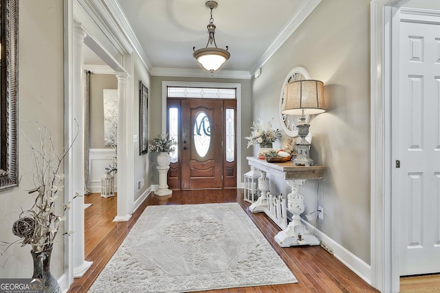 entryway featuring hardwood / wood-style floors, ornamental molding, and decorative columns