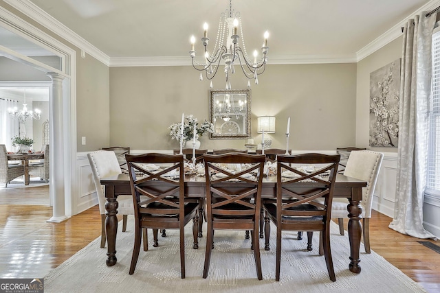 dining space featuring ornamental molding, light hardwood / wood-style flooring, and decorative columns