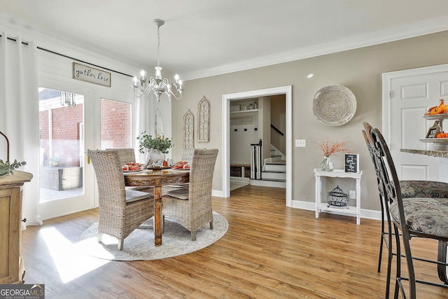 dining room featuring light hardwood / wood-style flooring, a chandelier, and ornamental molding