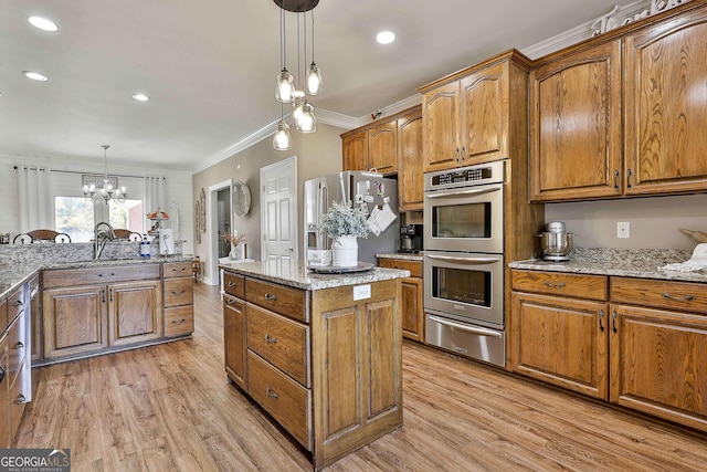 kitchen featuring light stone countertops, stainless steel appliances, light hardwood / wood-style flooring, decorative light fixtures, and ornamental molding