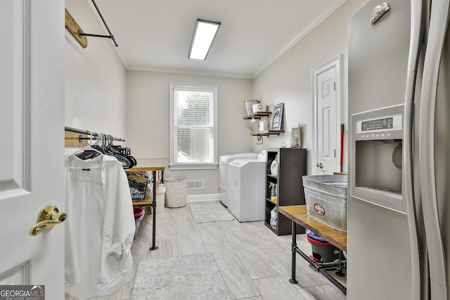 laundry area featuring washer and dryer and crown molding