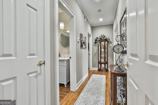 hallway with sink and light hardwood / wood-style flooring