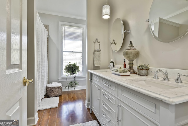 bathroom with crown molding, hardwood / wood-style floors, and vanity