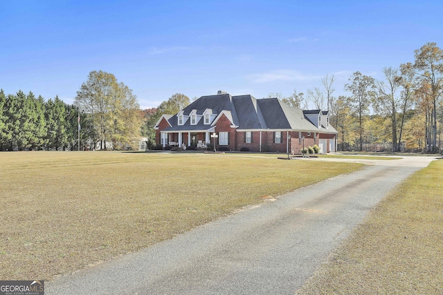 cape cod house with a porch, a garage, and a front lawn